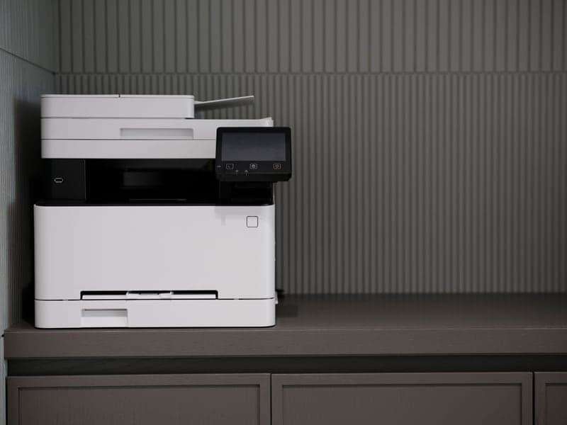 A modern printer on a minimalist office desk