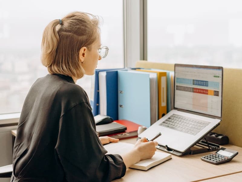 A person reviewing data on a laptop at a desk