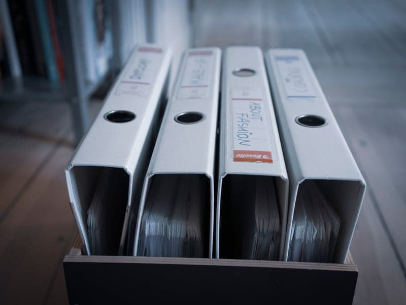 Folders with plastic sleeves arranged on a wooden surface