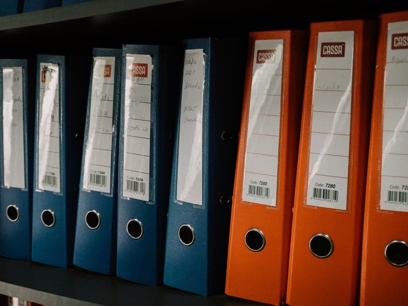Color-coded binders arranged neatly on a shelf